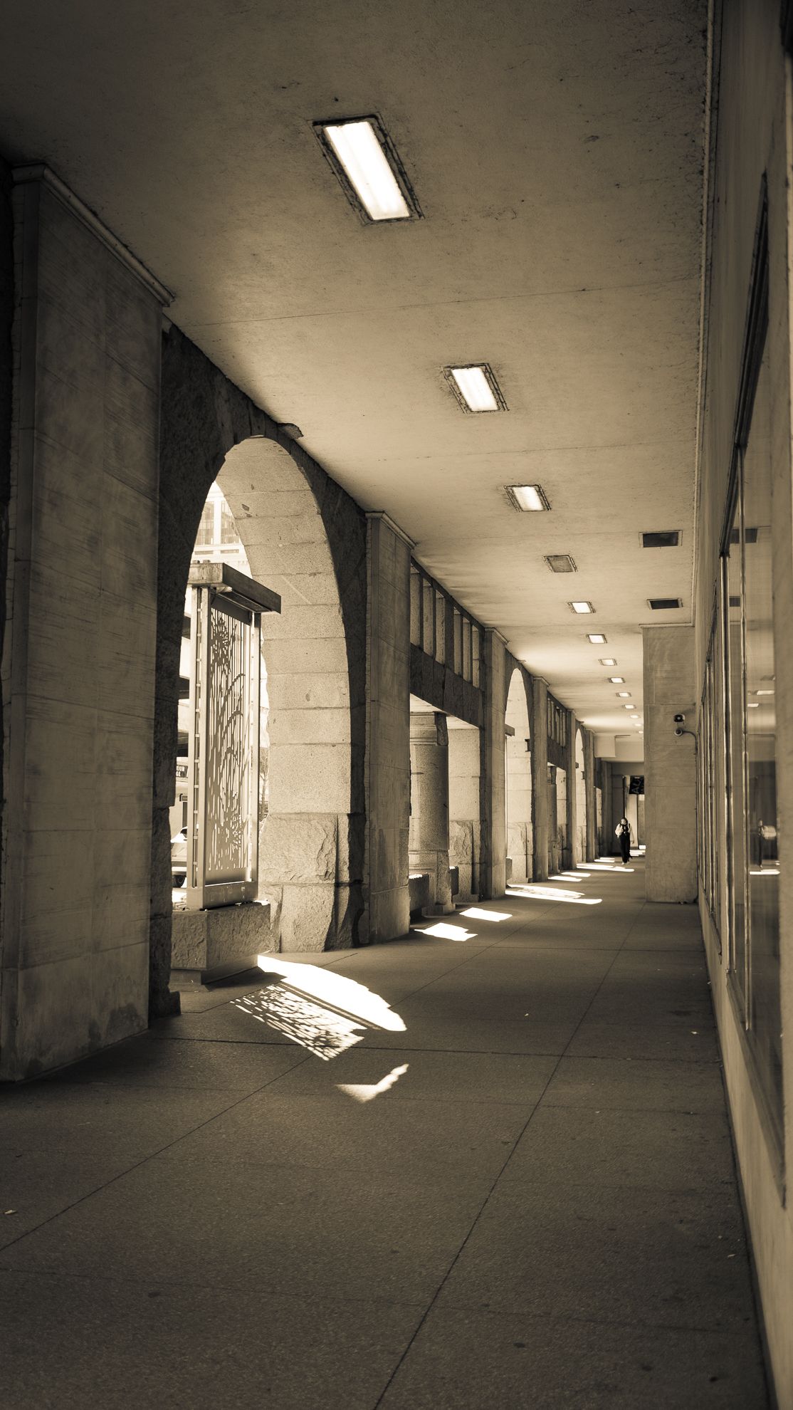 Sunlight falling through a concrete arcade, sepia