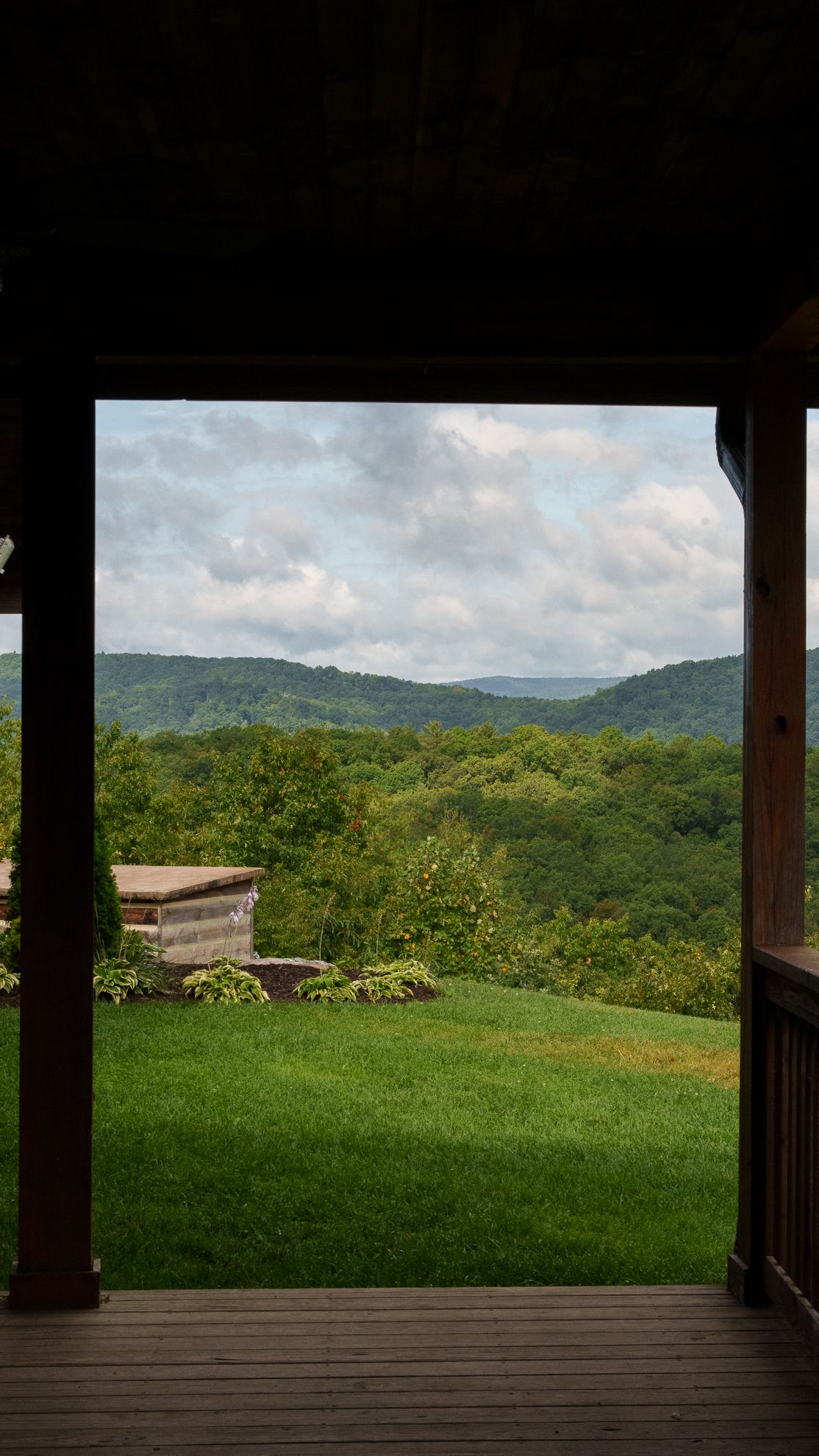 A mountain ridge view framed by a cabin porch's timber posts