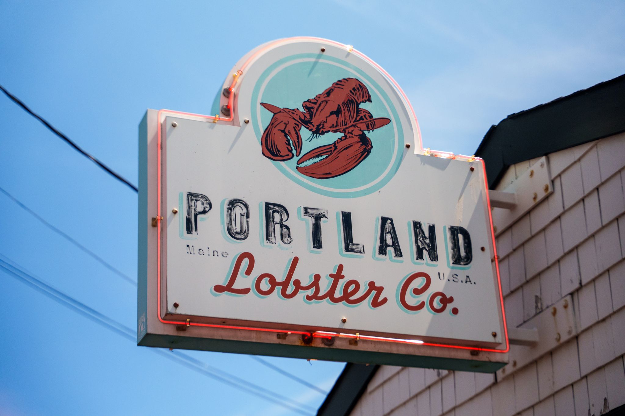 The Portland Lobster Co. sign against a blue Maine sky
