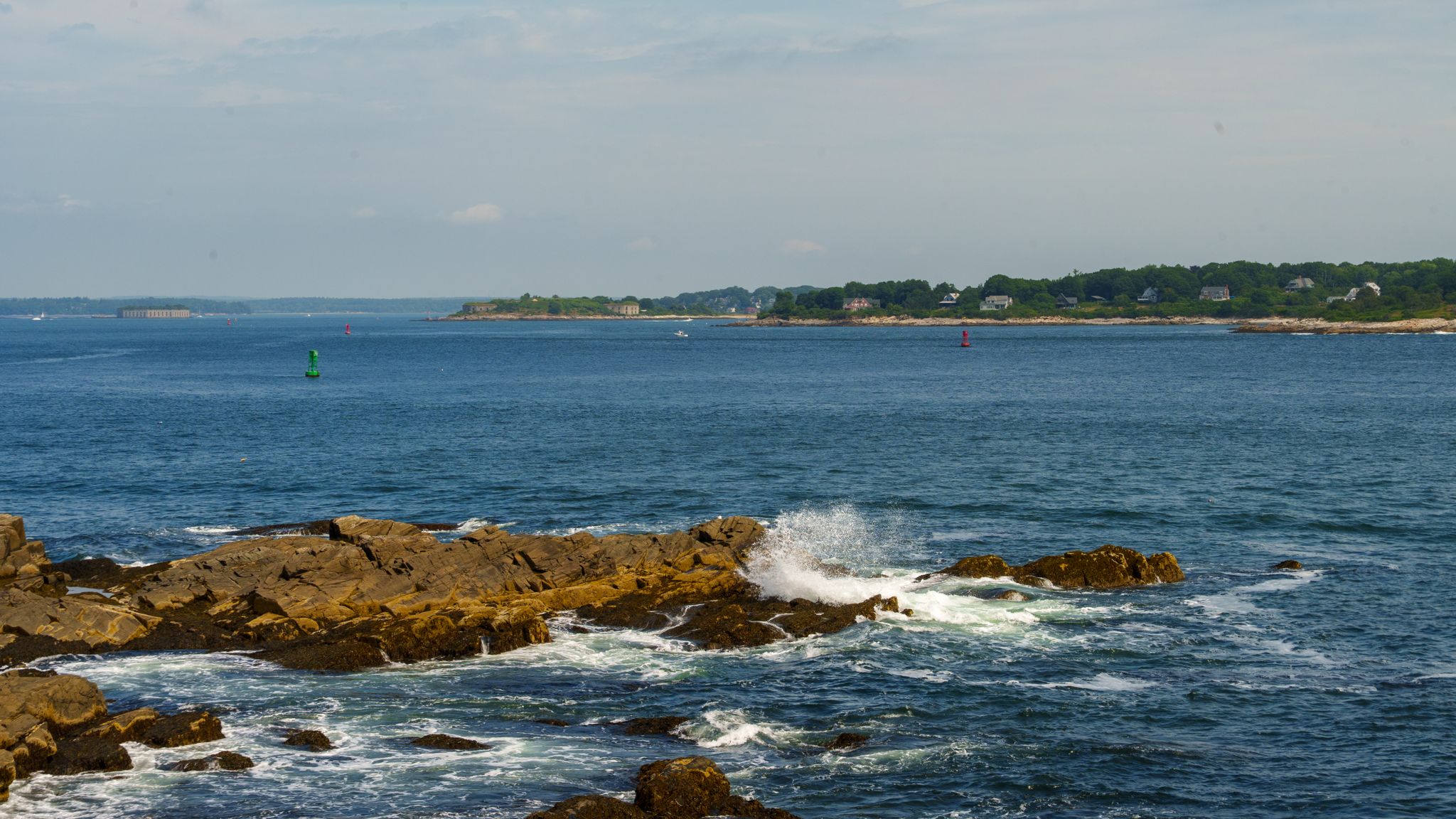 Channel buoys marking the passage off a rocky point